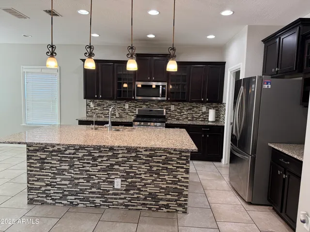 a kitchen with kitchen island a counter top space a sink appliances and cabinets