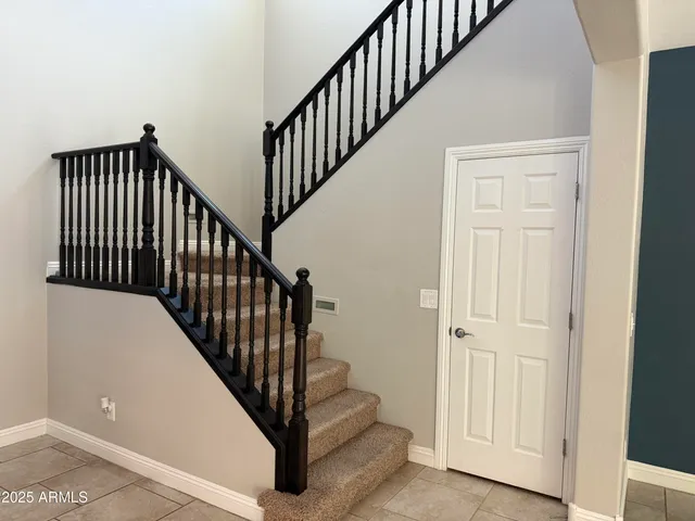 a view of staircase with lots of frames on wall and a wooden floor
