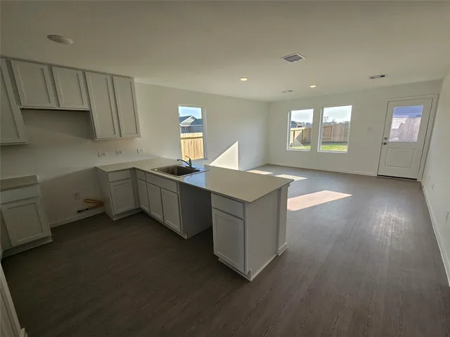 a kitchen with stainless steel appliances a sink dishwasher a stove a refrigerator with wooden cabinets