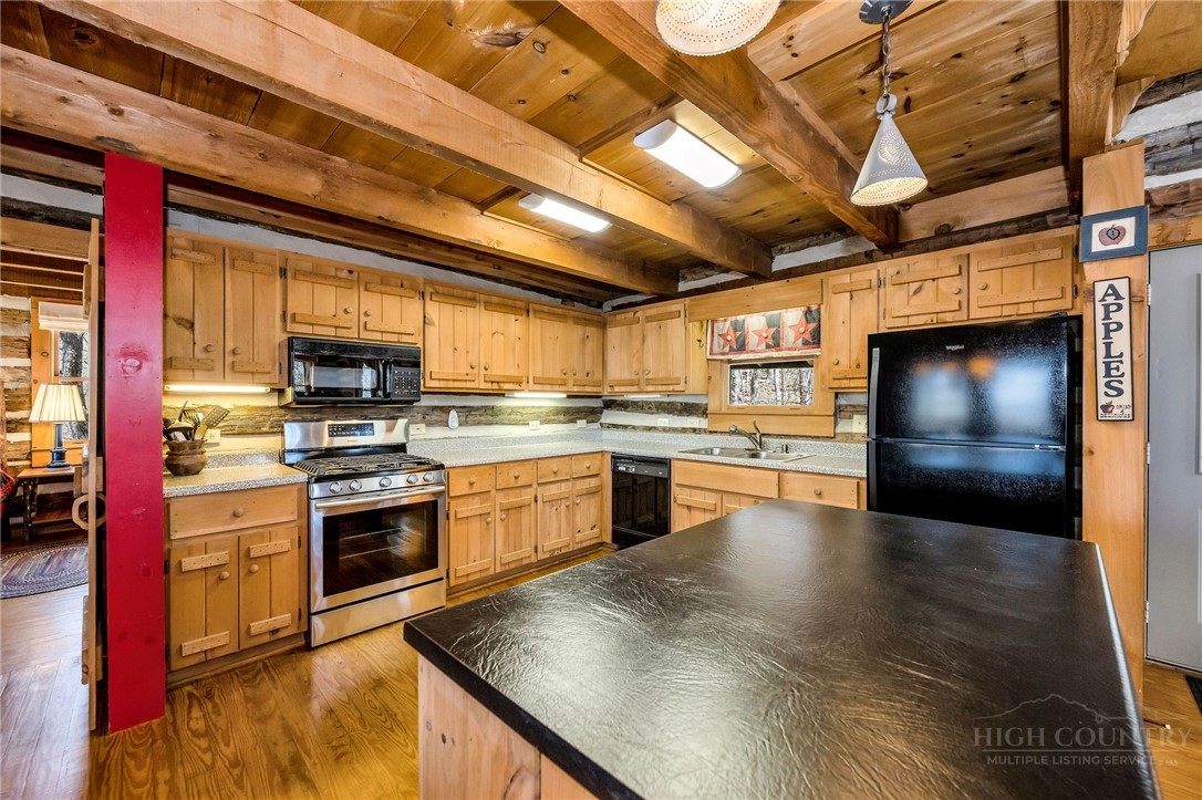 1992 Homestead Road Todd, NC 28684 - Photo 16 of 44 a kitchen with stainless steel appliances kitchen island granite countertop a stove a sink and a microwave