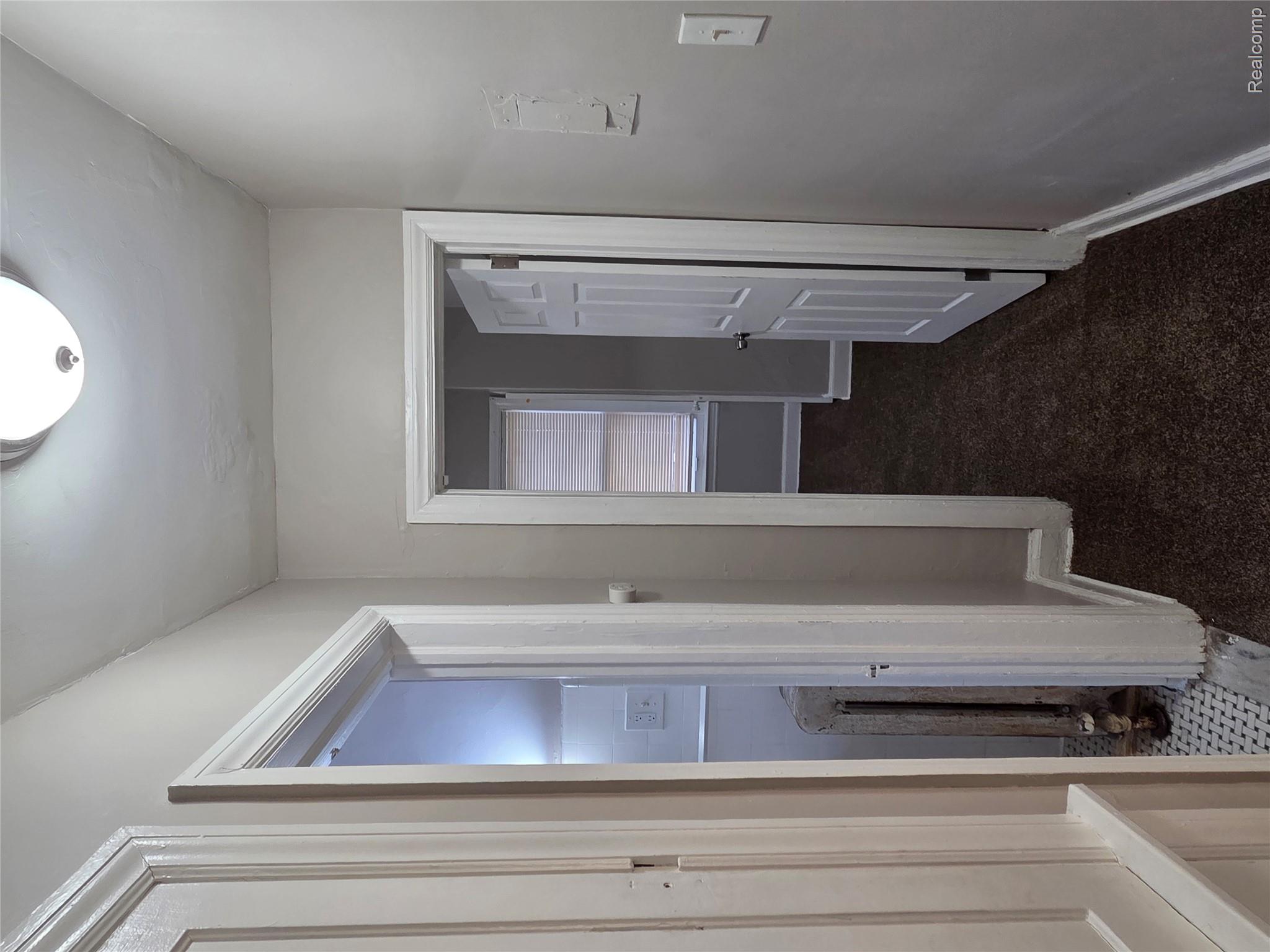 5274 Nottingham Road Detroit, MI 48224 - Photo 6 of 18 Corridor with dark carpet and radiator