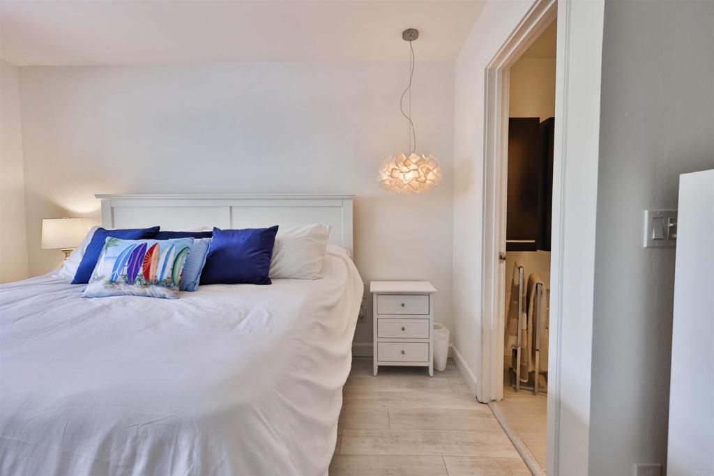 942 D Avenue, Unit B Coronado, CA 92118 - Photo 14 of 38 a bedroom with a large bed and a chandelier