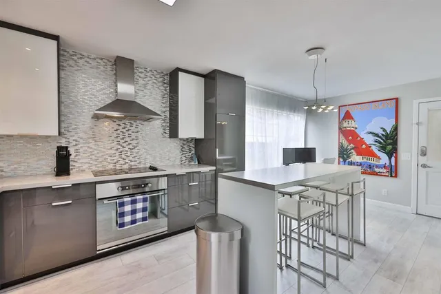 a kitchen with stainless steel appliances granite countertop a stove a sink dishwasher and a refrigerator with wooden floor