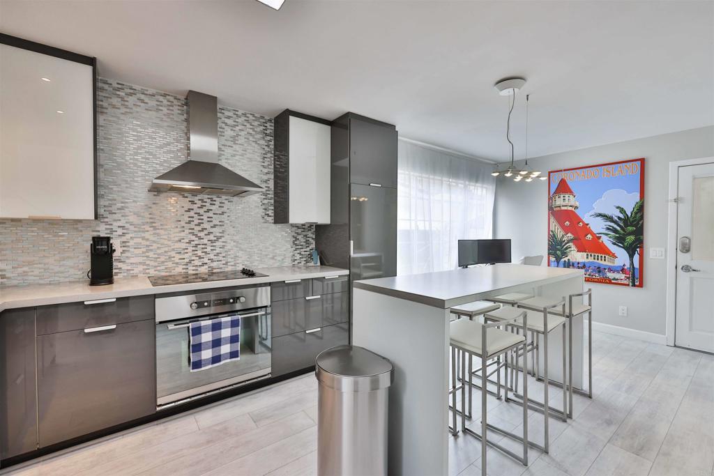 942 D Avenue, Unit B Coronado, CA 92118 - Photo 23 of 38 a kitchen with stainless steel appliances granite countertop a stove a sink dishwasher and a refrigerator with wooden floor