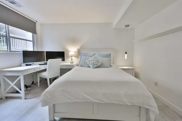 a bedroom with a bed and a computer on a desk