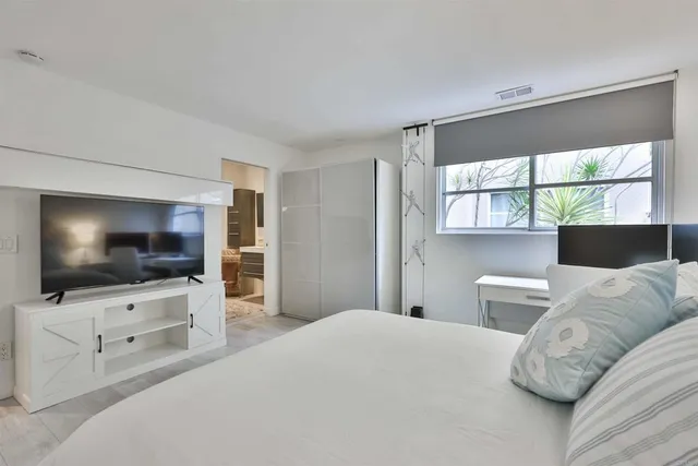 a bedroom with a bed and a flat screen tv