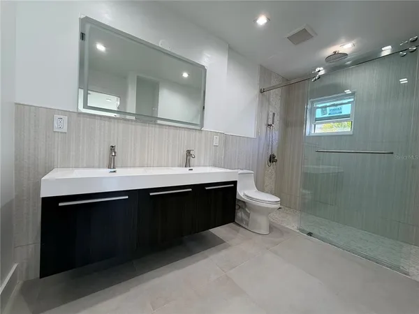a bathroom with a double vanity sink toilet and shower
