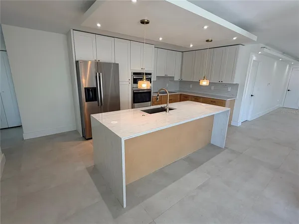 a kitchen with a sink a refrigerator and a oven