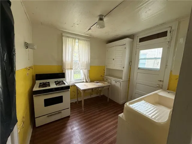 a kitchen with a stove and a wooden floor