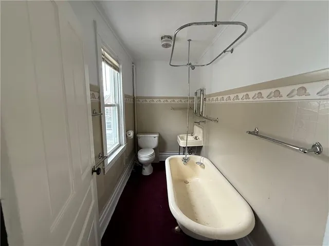 a bathroom with a toilet a sink and mirror