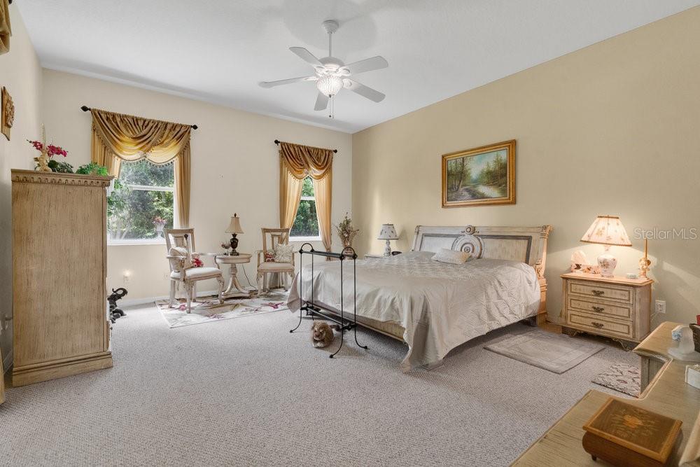 6139 Andreozzi Lane Windermere, FL 34786 - Photo 26 of 53 a spacious bedroom with a bed and a chandelier