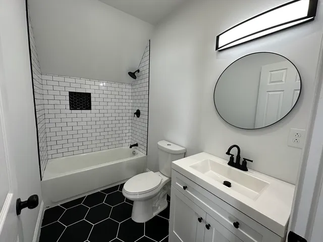 a bathroom with a sink a toilet and a mirror
