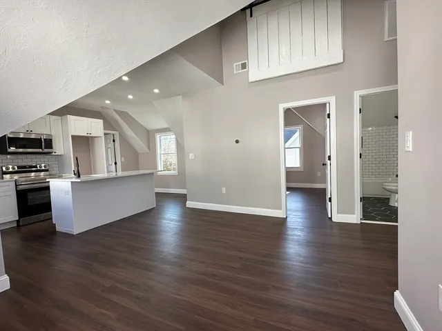 a view of a kitchen with wooden floor and electronic appliances