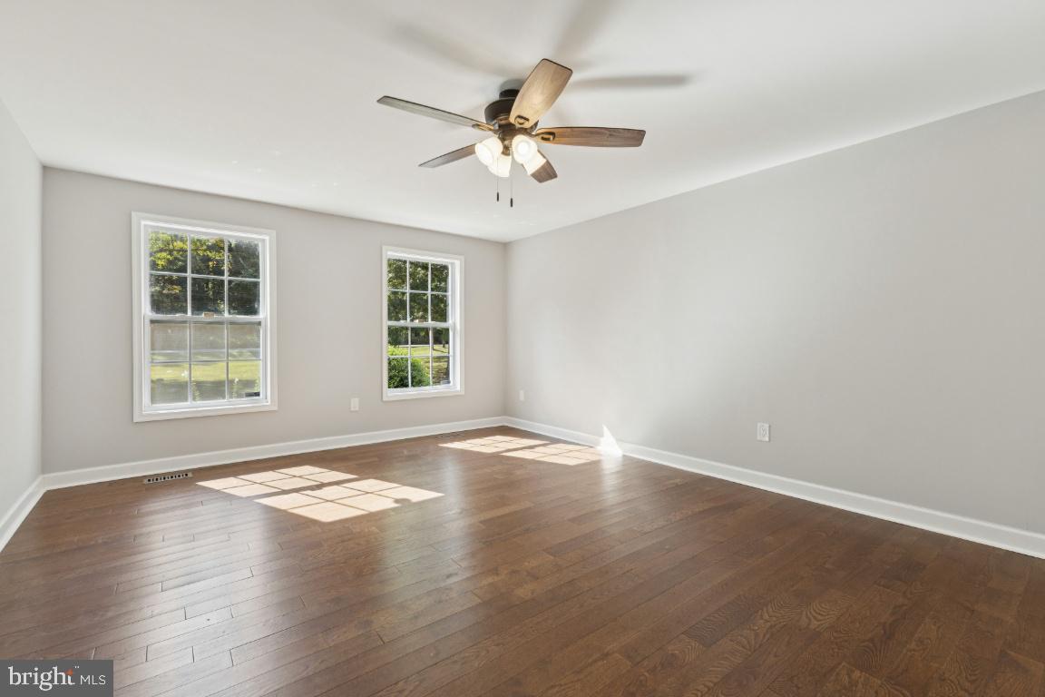 8368 Brock Bridge Road Laurel, MD 20724 - Photo 15 of 37 an empty room with wooden floor chandelier fan and windows