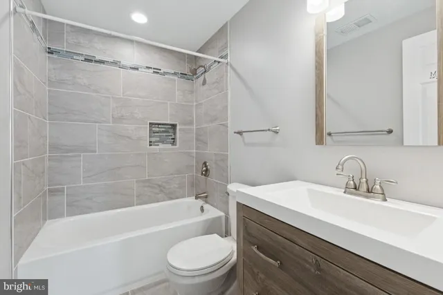 a bathroom with a sink a mirror toilet and bathtub