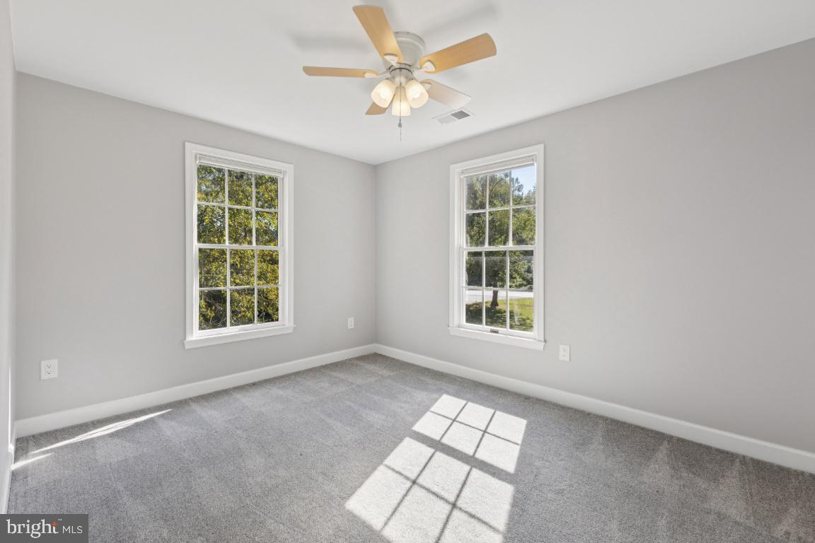 8368 Brock Bridge Road Laurel, MD 20724 - Photo 20 of 37 an empty room with chandelier fan and windows