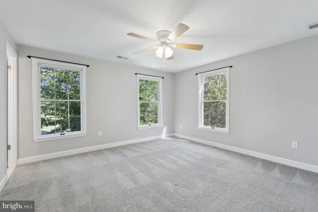 an empty room with a window and a fan
