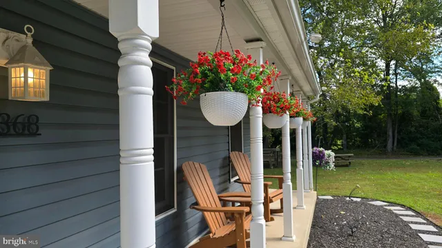 a view of a chairs and table in backyard of a house