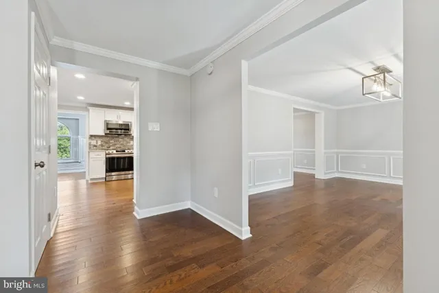 wooden floor in an empty room with a kitchen