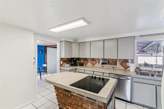 a kitchen with a sink and a refrigerator a mirror