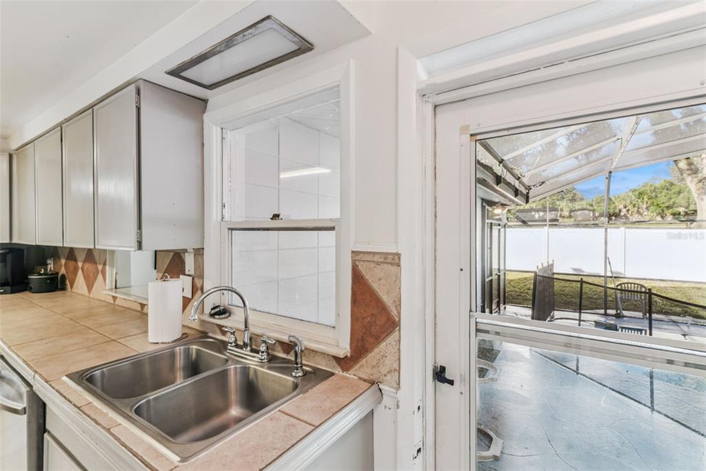 2508 Good Homes Road Orlando, FL 32818 - Photo 16 of 30 a kitchen with a sink and a refrigerator a mirror