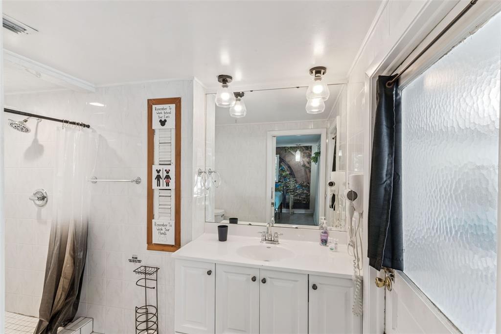 2508 Good Homes Road Orlando, FL 32818 - Photo 27 of 30 a bathroom with a shower sink and mirror