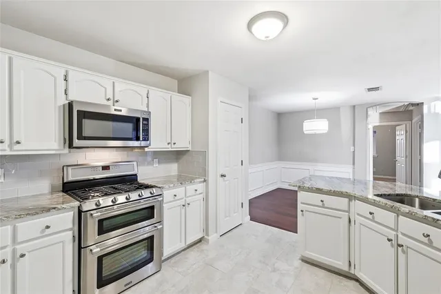 a kitchen with granite countertop a stove and a sink