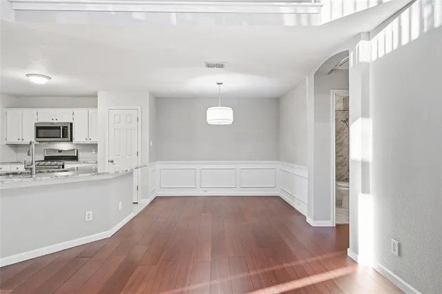 a view of a kitchen with wooden floor and electronic appliances