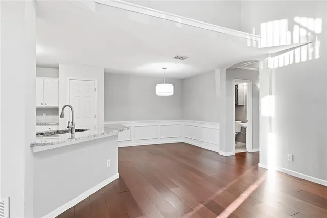 a view of a kitchen with a sink and dishwasher with wooden floor