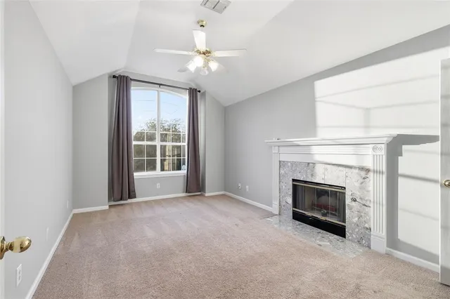an empty room with fireplace and windows
