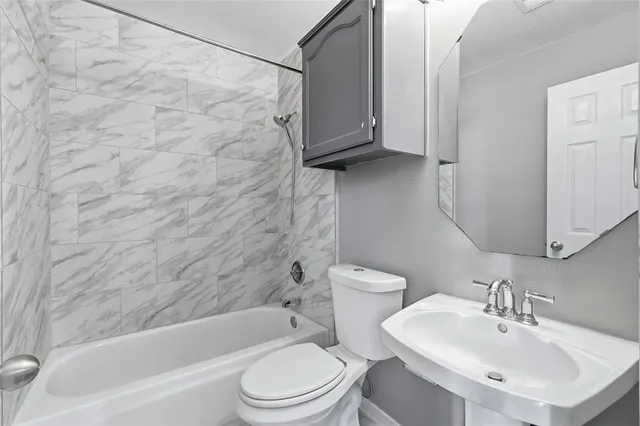 a bathroom with a white bath tub a sink and a toilet