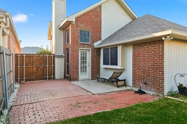 a view of backyard with brick wall and a chair