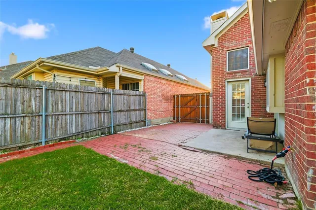 a view of backyard with barbeque grill and wooden fence