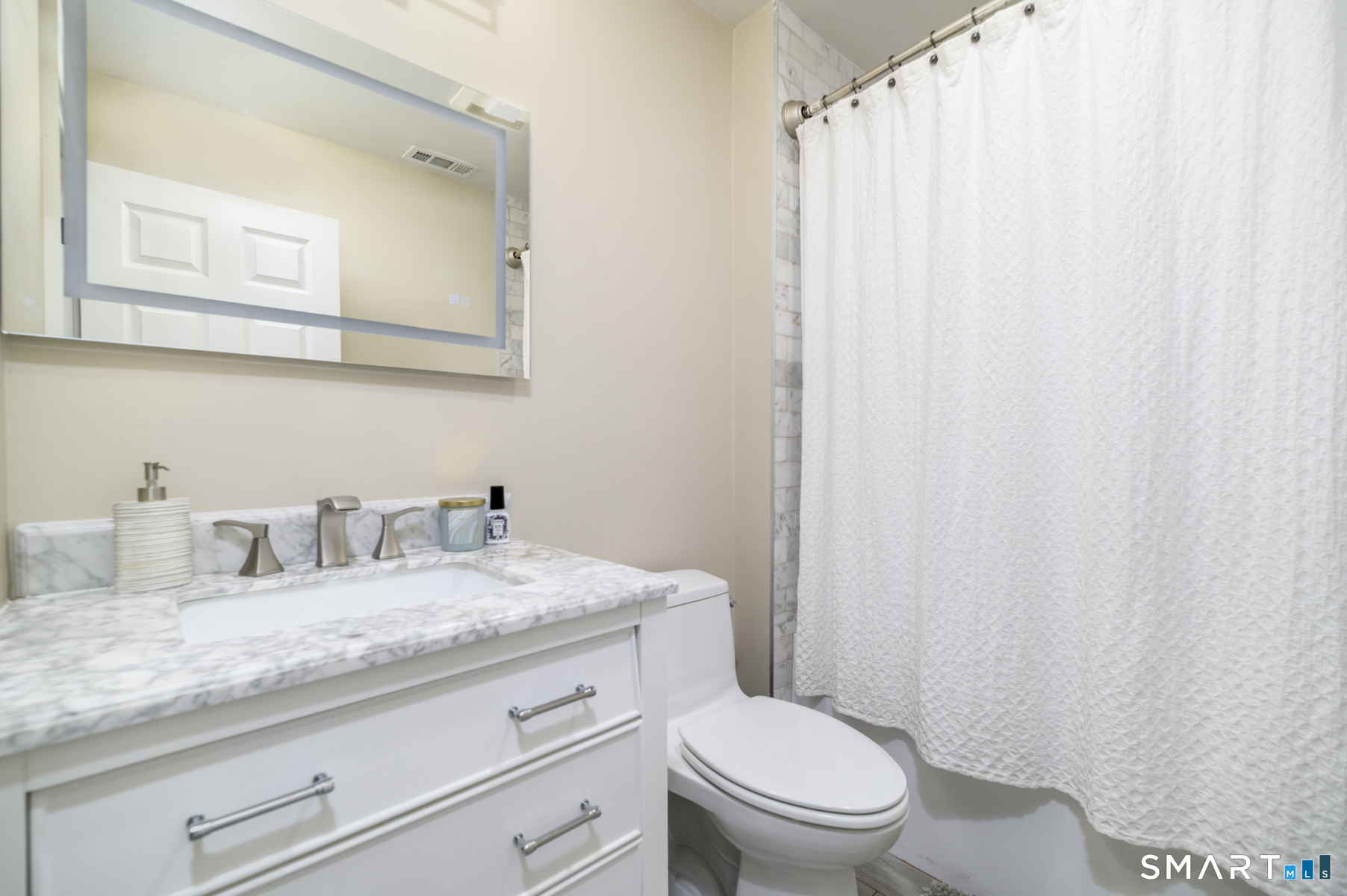 130 Main Street, Unit E4 Norwalk, CT 06851 - Photo 19 of 32 a bathroom with a granite countertop sink toilet and mirror