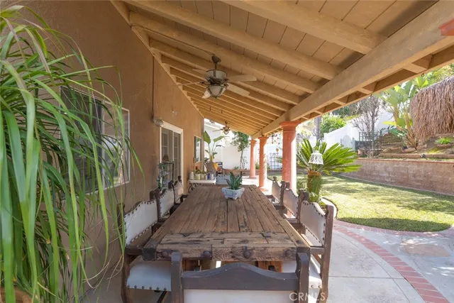 a view of a patio with table and chairs potted plants with wooden floor and fence