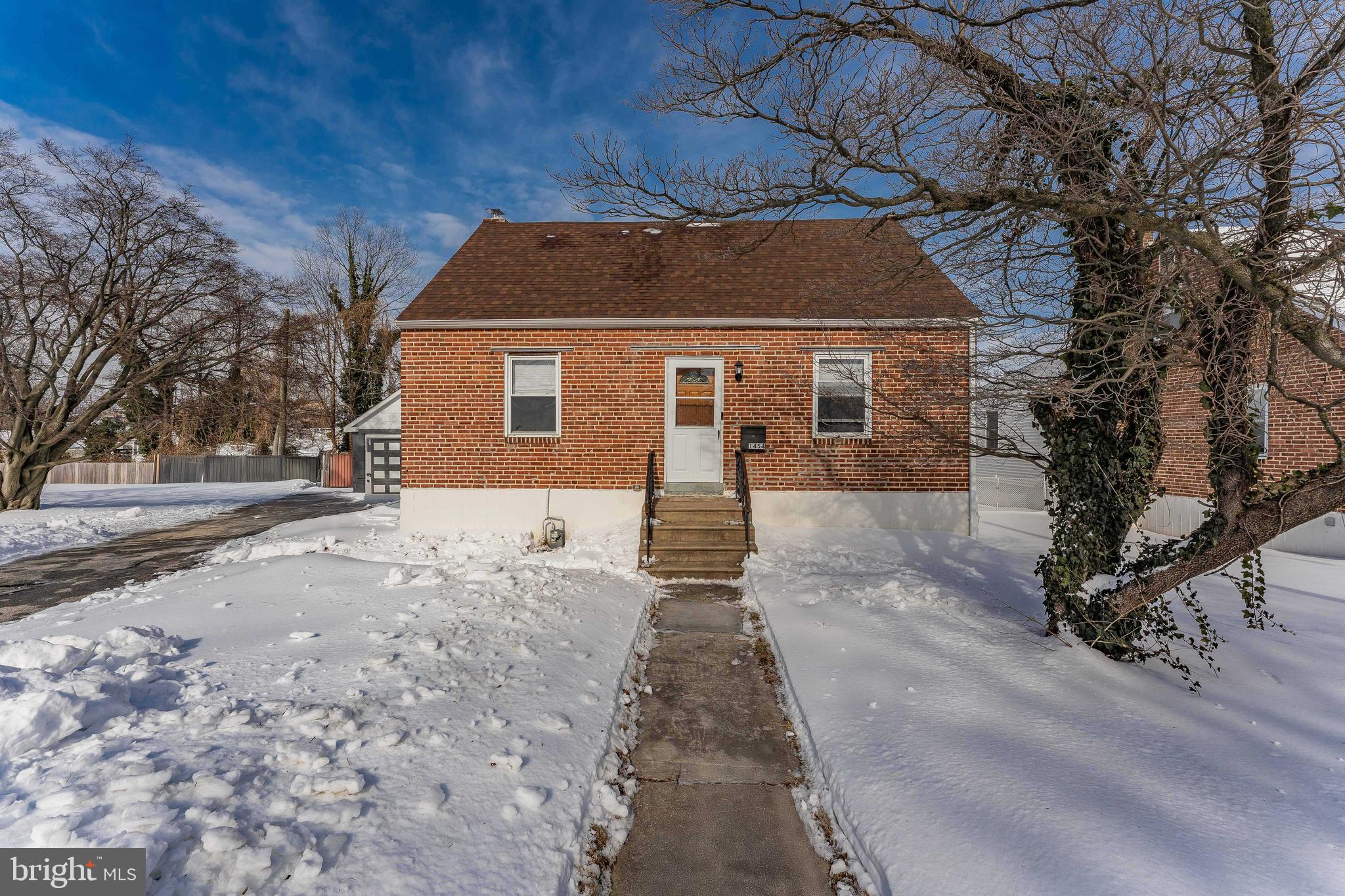 a front view of house with yard and trees around