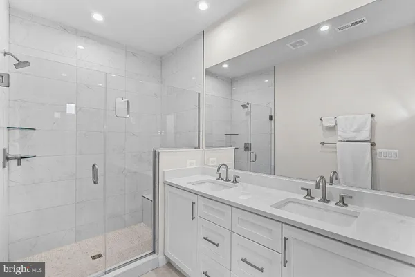 a bathroom with a shower sink vanity and mirror