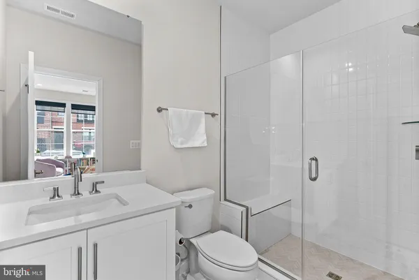 a bathroom with a sink toilet vanity and shower