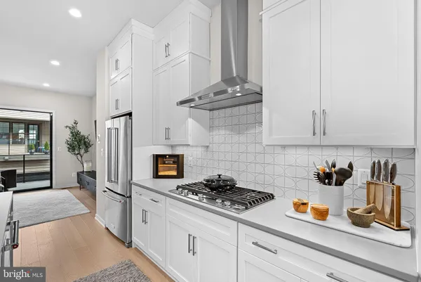a kitchen with stainless steel appliances granite countertop a stove a sink and a white cabinets