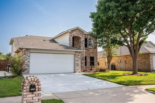 a front view of a house with a yard and garage