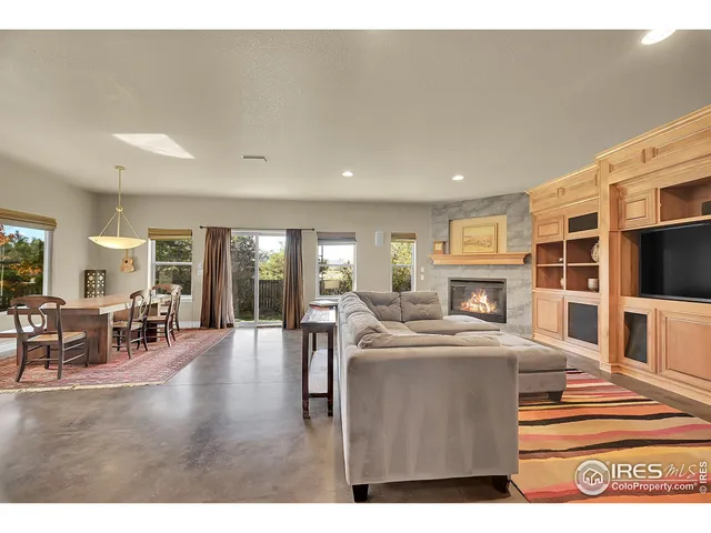 a living room with furniture flat screen tv and a large window