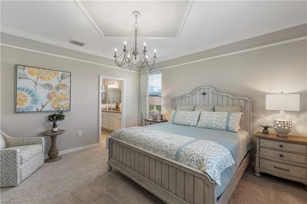 16100 Bonita Landing Circle Bonita Springs, FL 34135 - Photo 14 of 28 a bedroom with a large bed and a chandelier