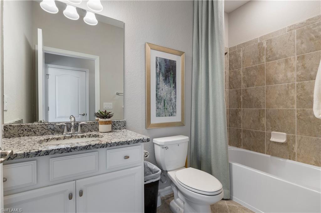 16100 Bonita Landing Circle Bonita Springs, FL 34135 - Photo 19 of 28 a bathroom with a granite countertop toilet a sink and a bathtub