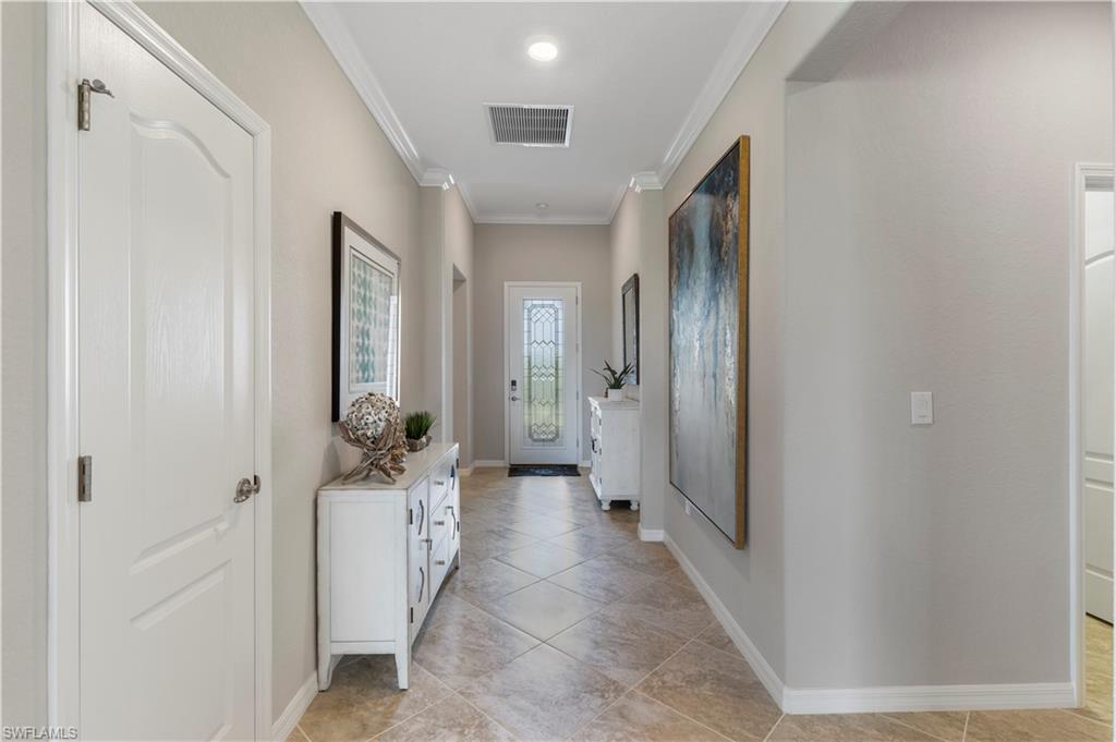 16100 Bonita Landing Circle Bonita Springs, FL 34135 - Photo 2 of 28 a hallway with white doors wooden cabinet and chandelier
