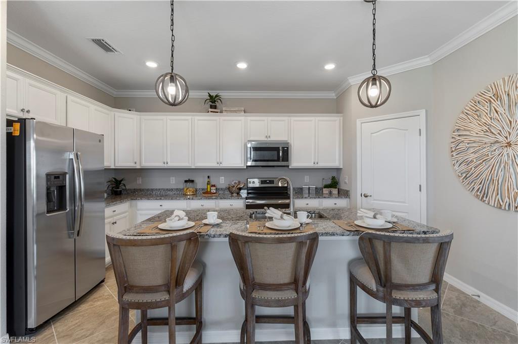 16100 Bonita Landing Circle Bonita Springs, FL 34135 - Photo 8 of 28 a kitchen with stainless steel appliances granite countertop a sink a stove a refrigerator cabinets and chairs