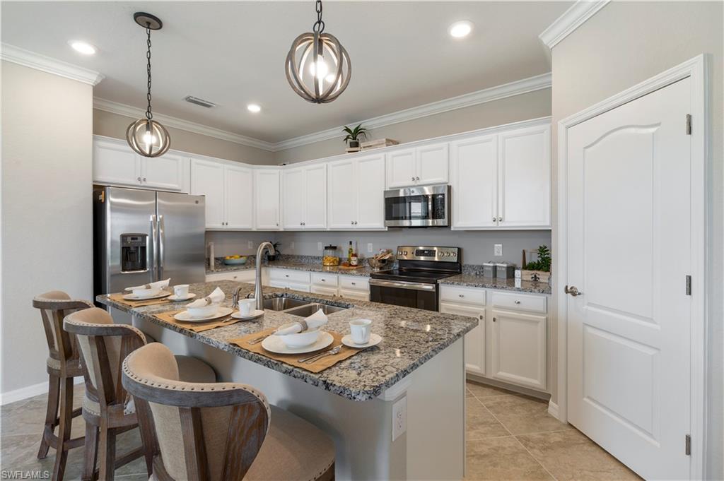16100 Bonita Landing Circle Bonita Springs, FL 34135 - Photo 9 of 28 a kitchen with a sink a stove and chairs