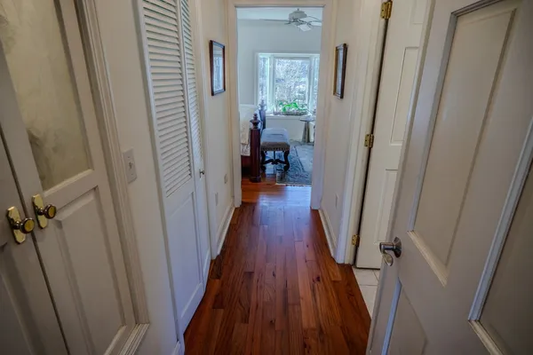 a hallway with painting on the wall and a large mirror