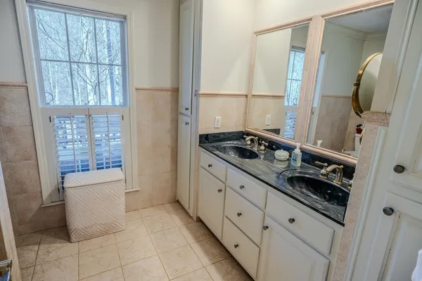 a bedroom with a bed and a chandelier next to a window