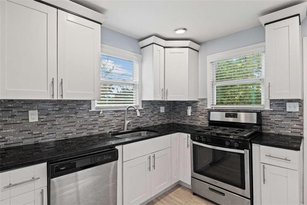 701 Daniel Avenue Decatur, GA 30032 - Photo 21 of 29 a kitchen with granite countertop white cabinets white appliances a sink and a window