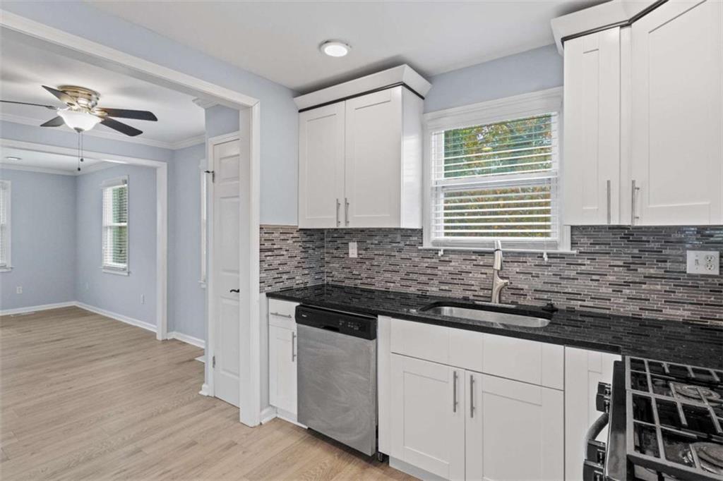 701 Daniel Avenue Decatur, GA 30032 - Photo 24 of 29 a kitchen with granite countertop a stove a sink and dishwasher with wooden floor